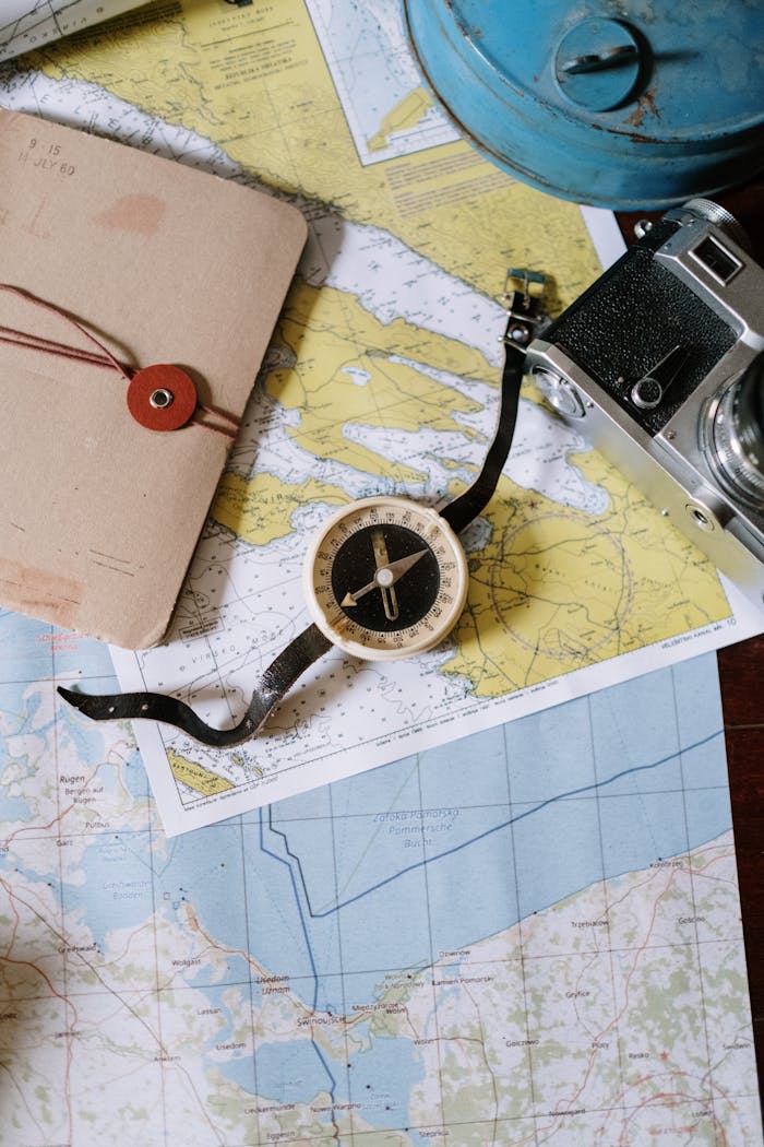 Compass and camera on a vintage map flat lay, perfect for travel planning and navigation themes.